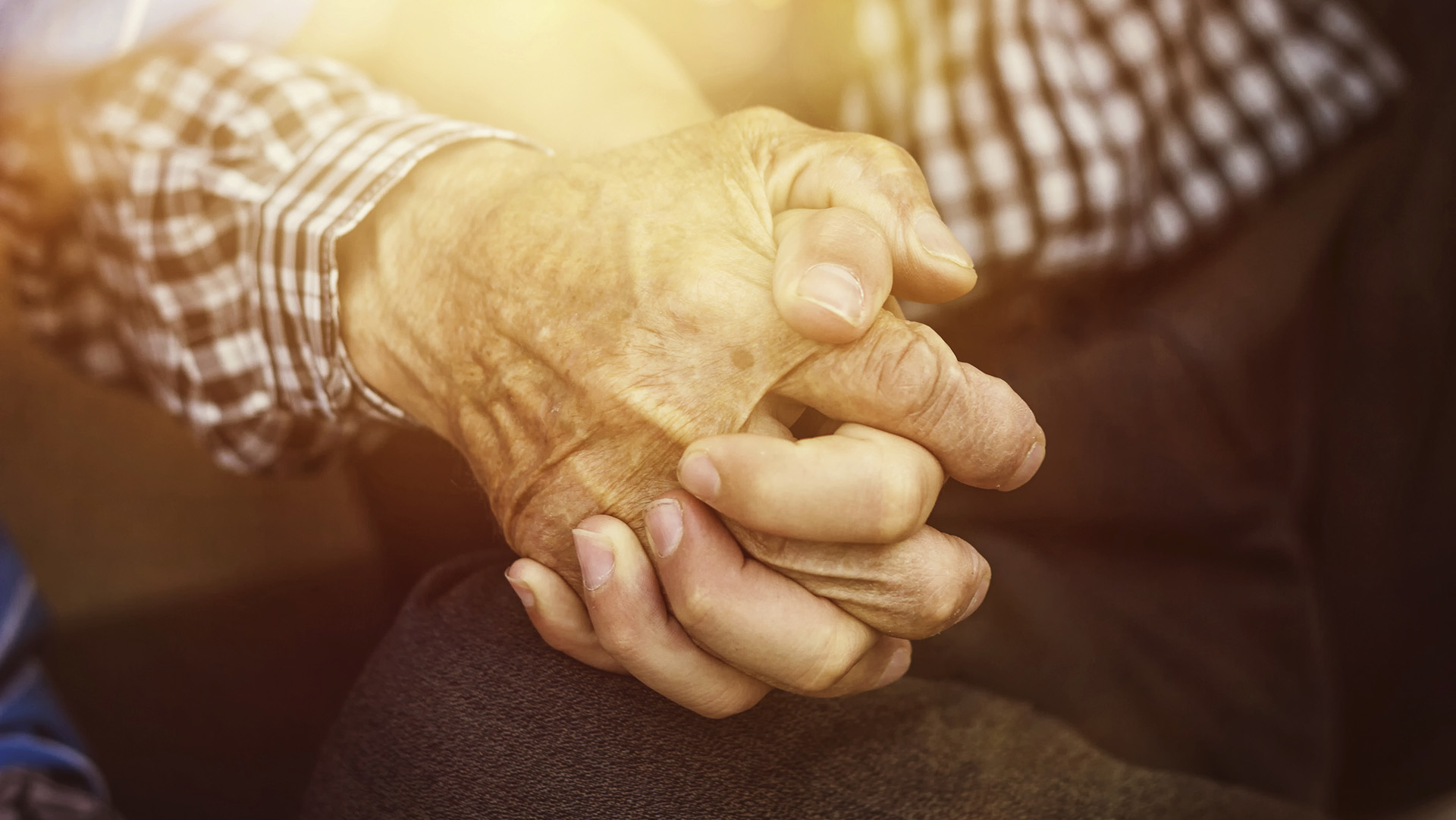 nephew holding strong grandfather's hand