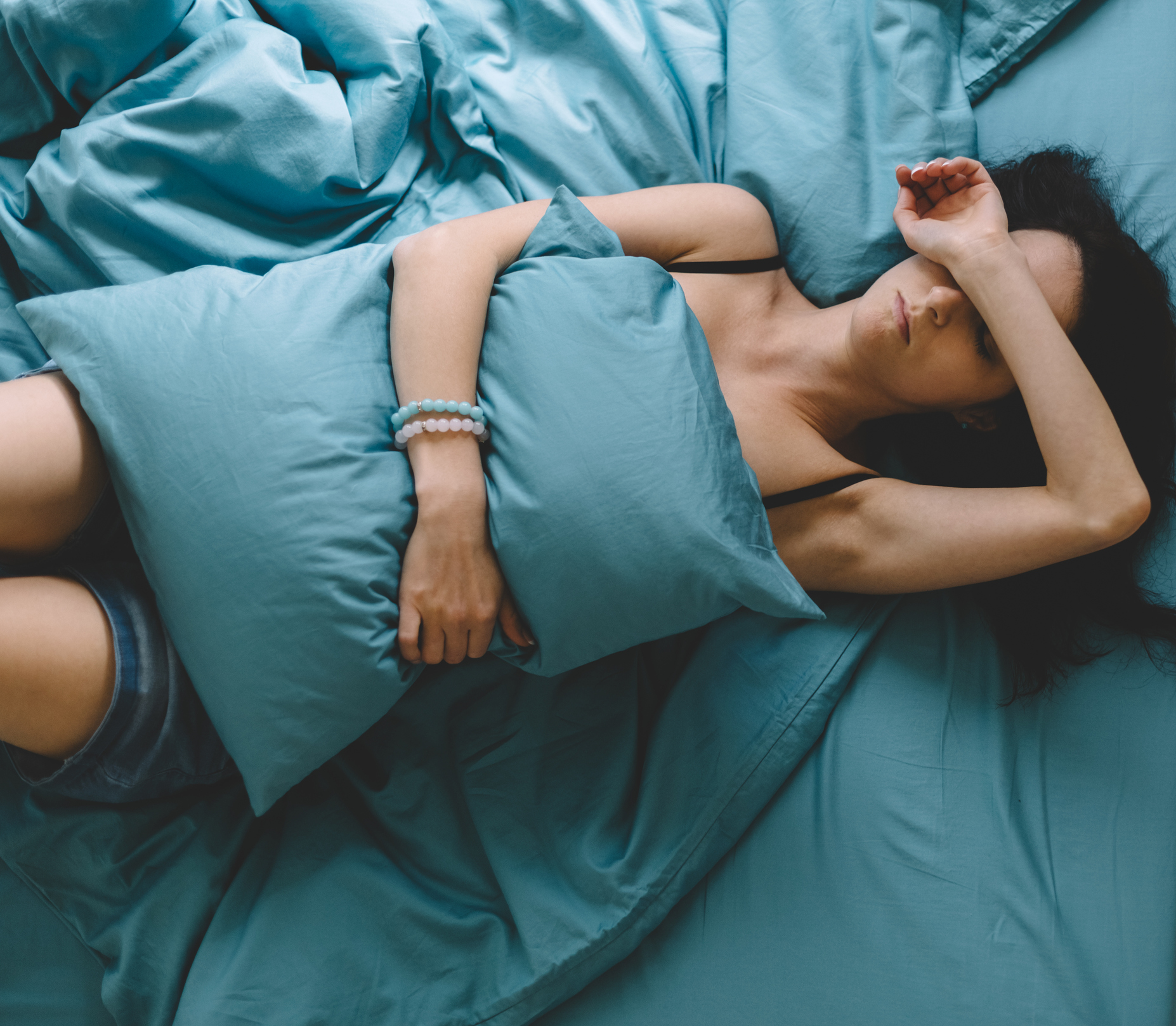 Depressed woman in bed with hand on forehead