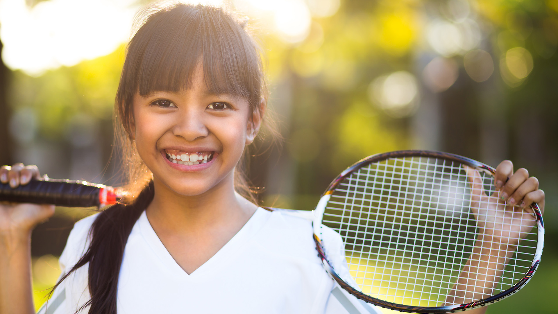 Closeup cute little asian girl holding a badminton racket, Outdoor