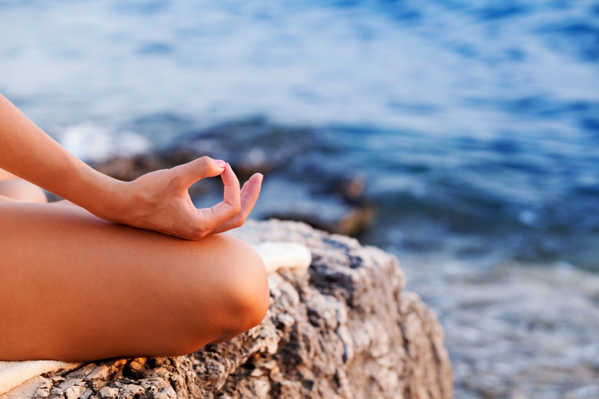 Woman doing yoga at sunset, lotus position, copy space