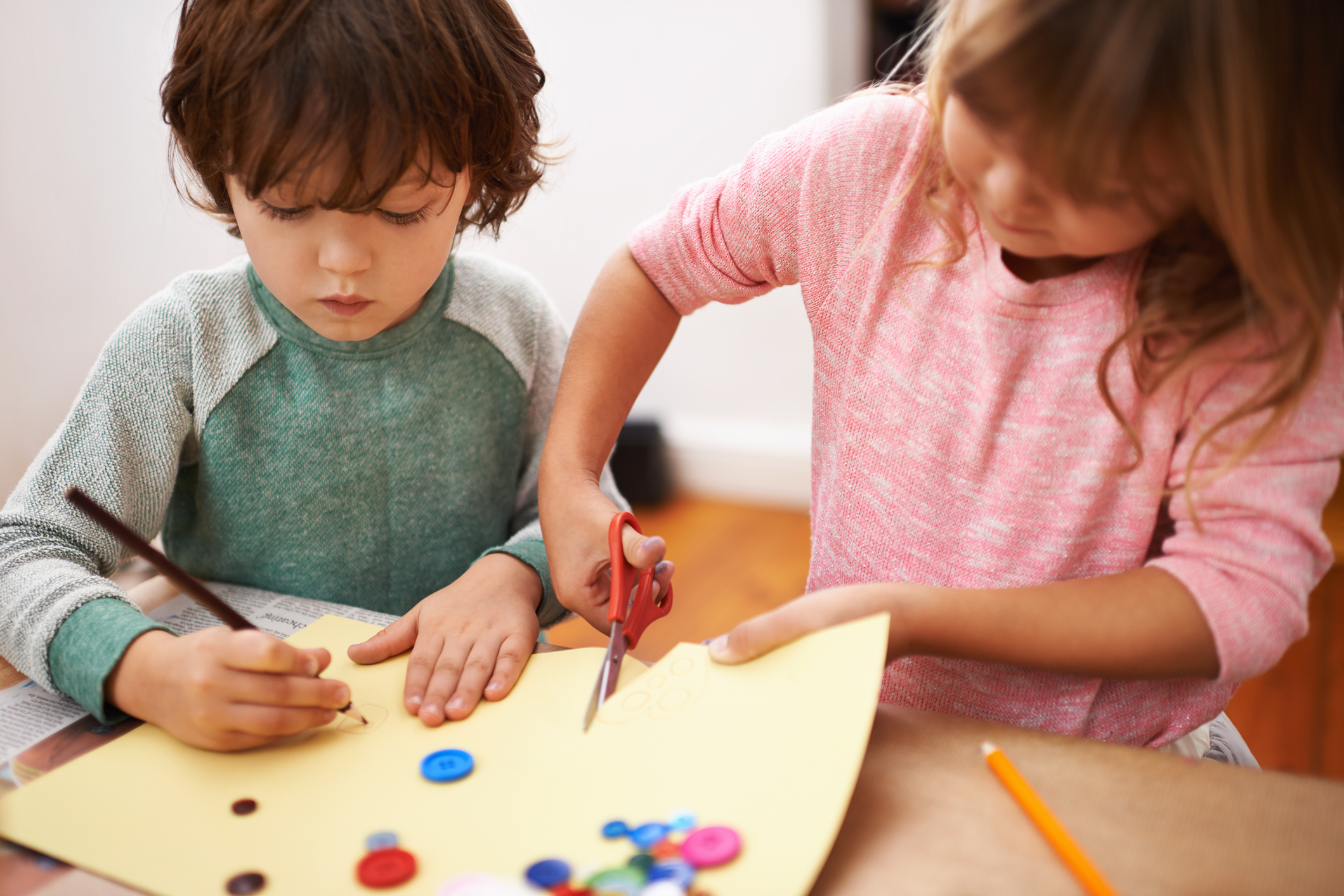 Cropped shot of two siblings cutting and drawing