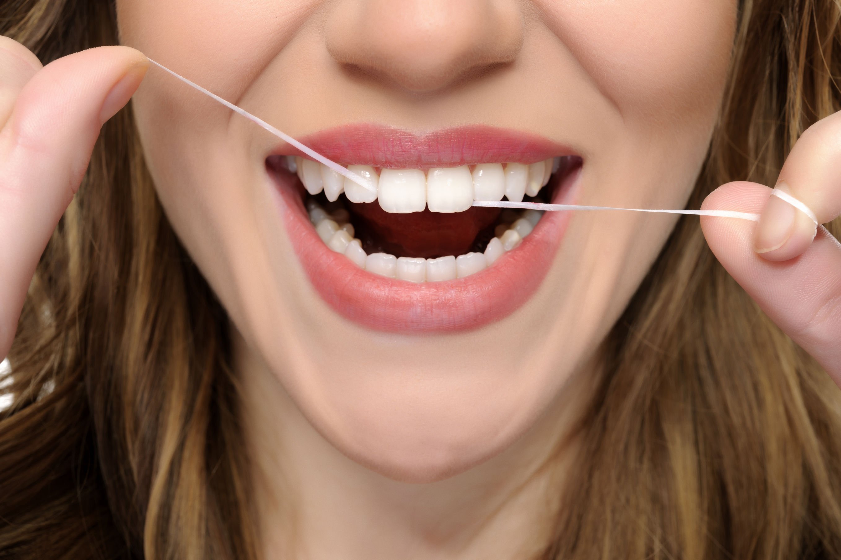 young woman mouth flossing her teeth.