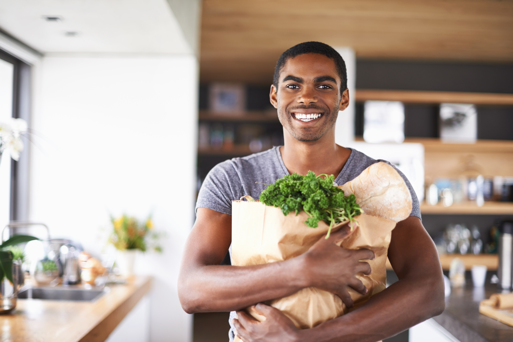 Shot of a young african man holding a bag of groceries indoorshttp://195.154.178.81/DATA/i_collage/pi/shoots/783494.jpg