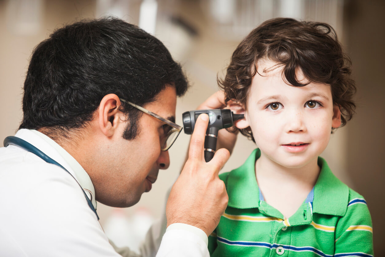 A doctor looking into a child's ear