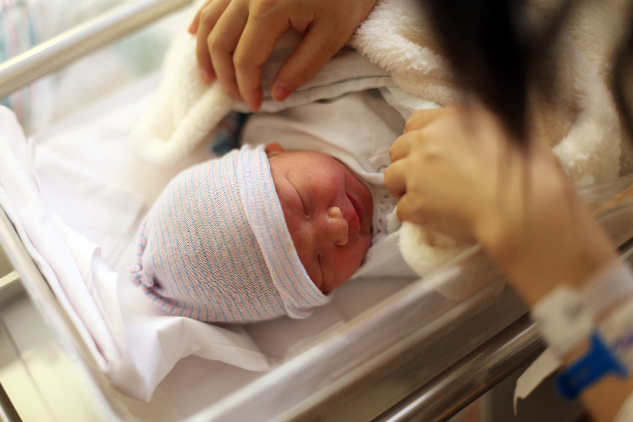 Looking over a newborn. Mother looks and fusses over a newborn baby.