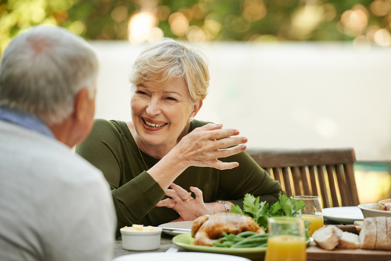 Shot of a happy elderly couple enjoying lunch together outside