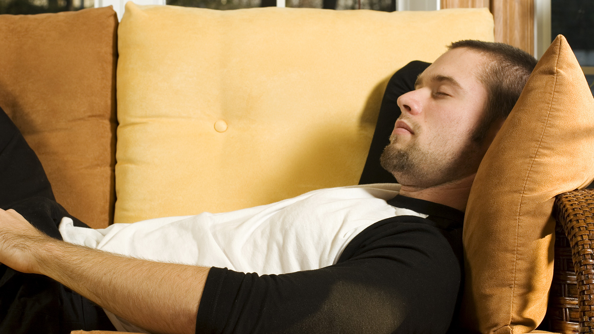 Young man having a nap on couch in living room