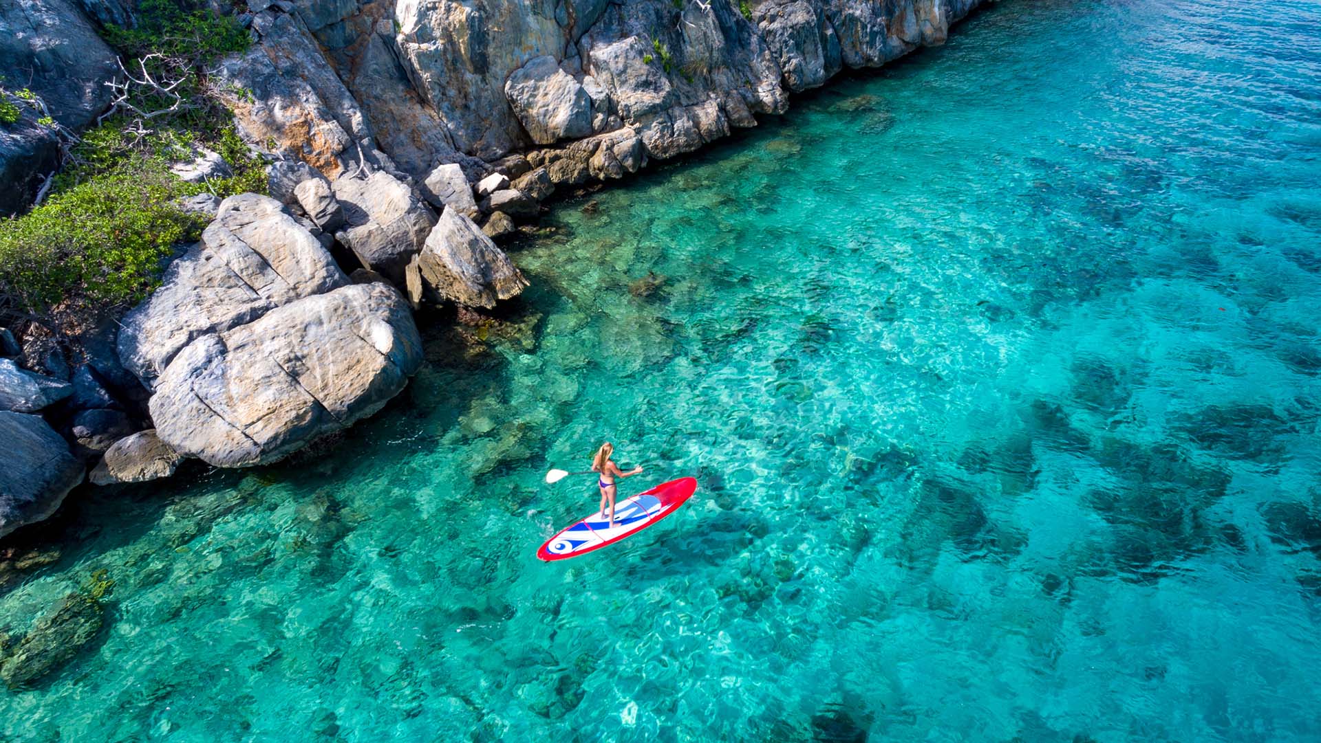 Aerial view of a woman on paddleboard in tropical water, Lovango Cay, United States Virgin Islands