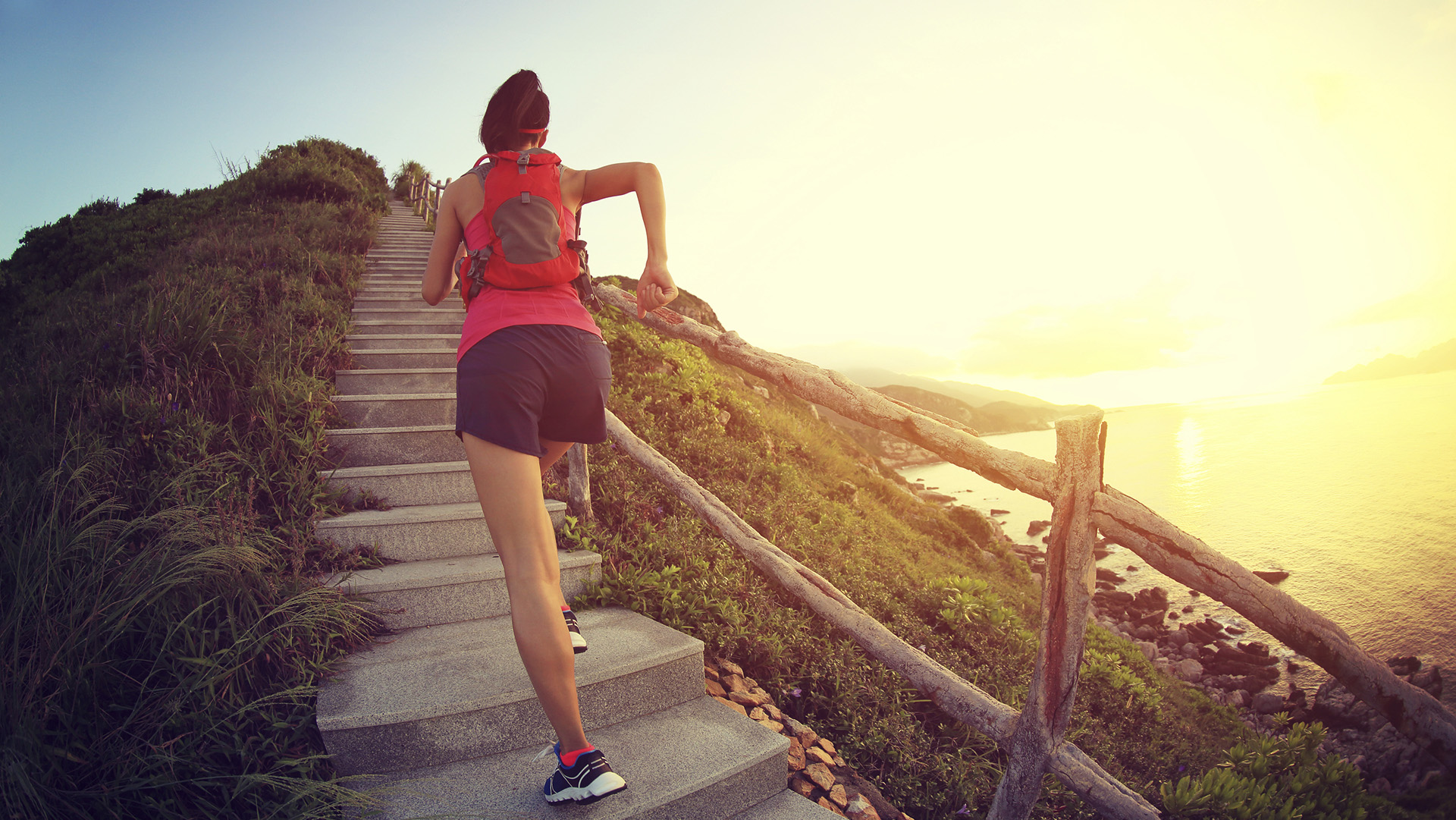 fitness woman runner trail running on seaside mountain stairs, training for cross country running.