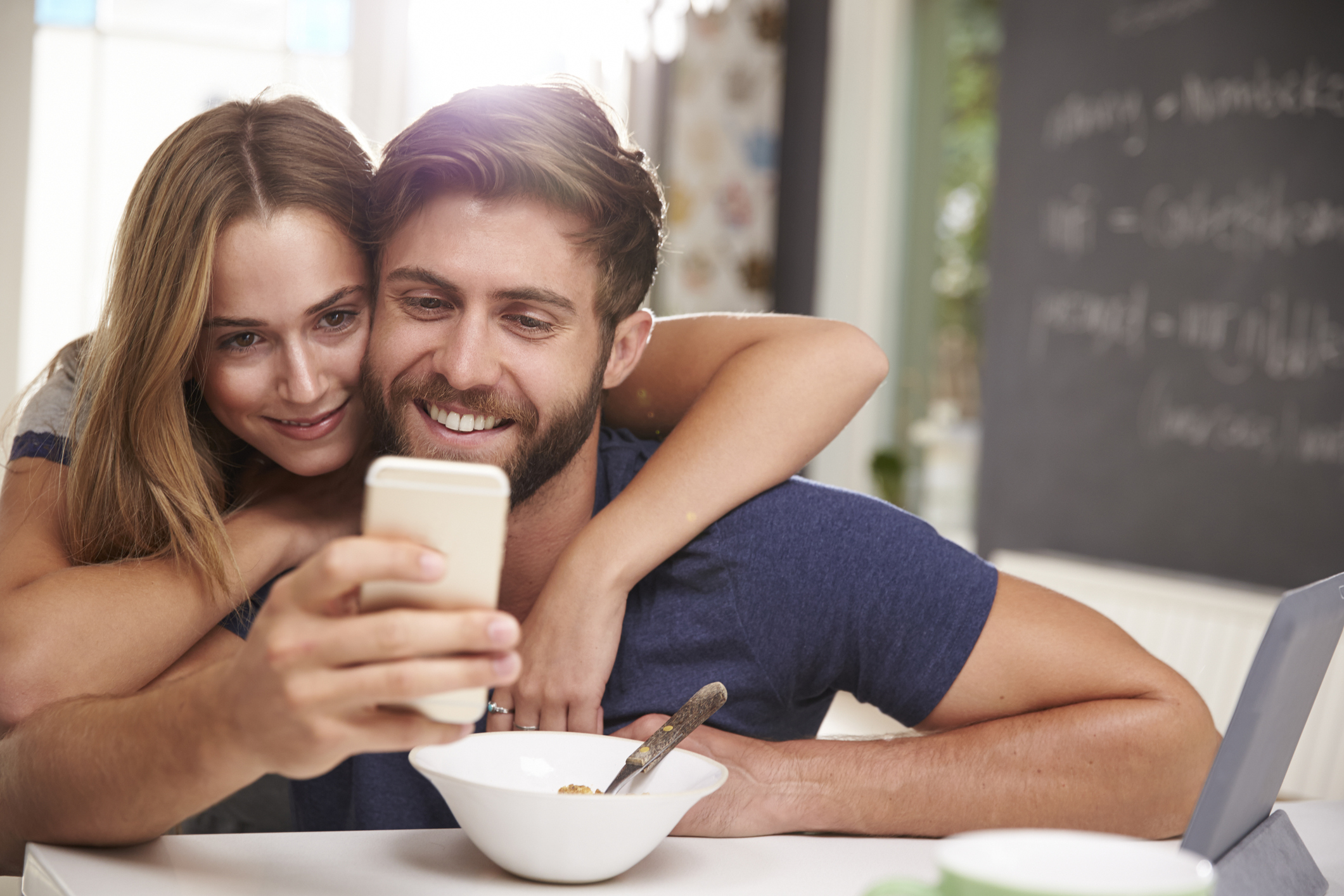 Couple Eating Breakfast Using Digital Tablet And Phone