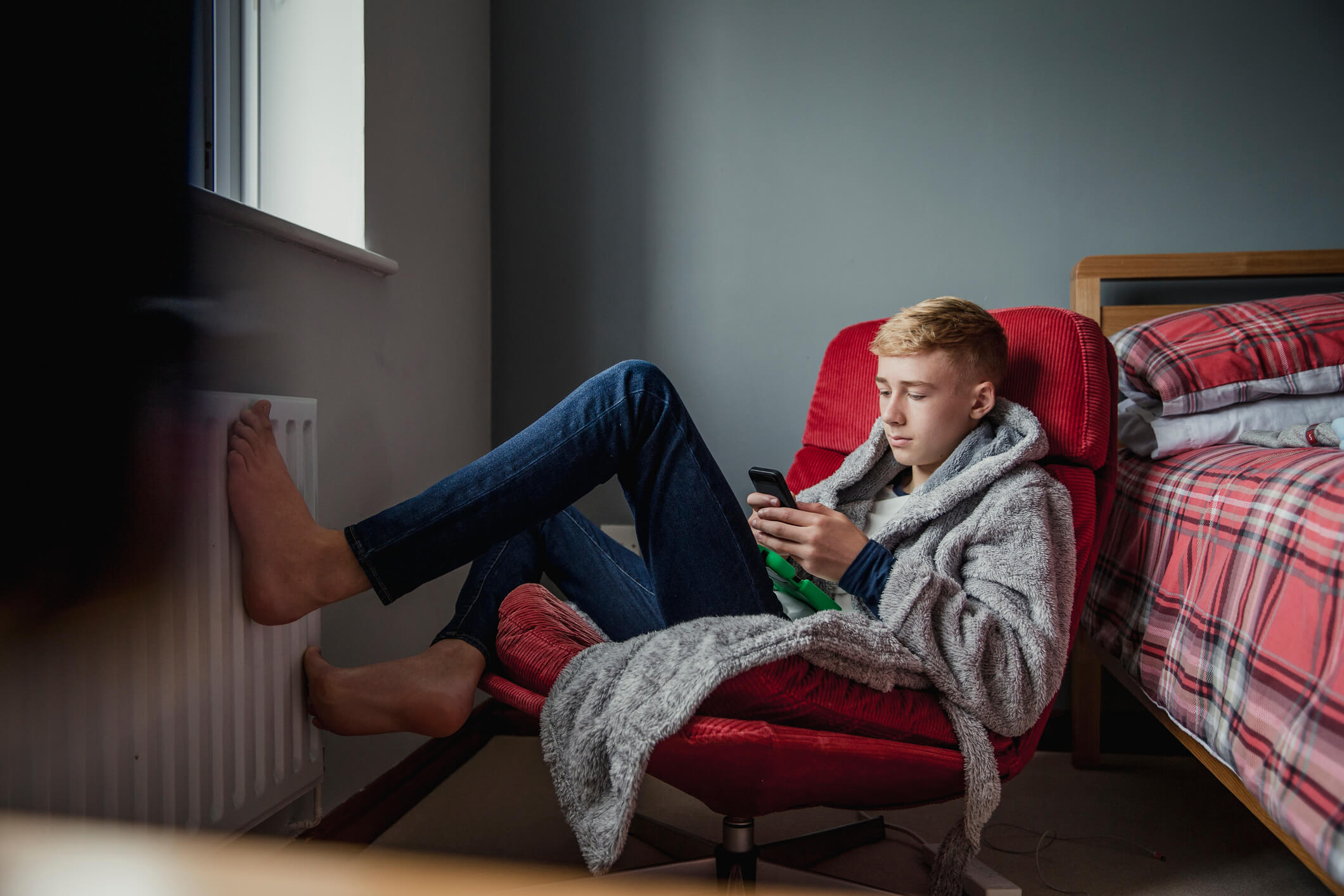 Teenage boy relaxing in his bedroom.