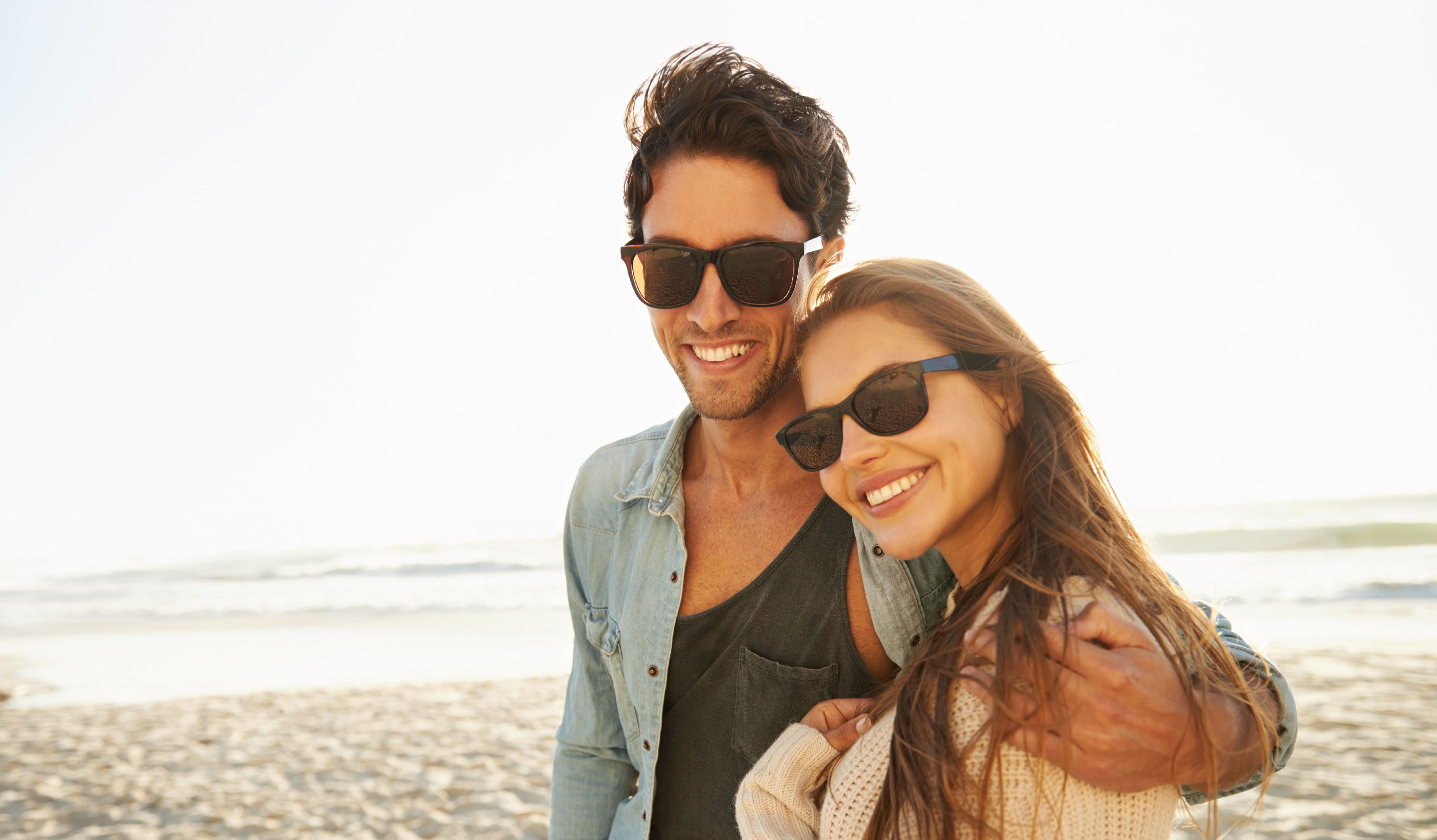 Portrait of a loving young couple standing and holding each other on the beach