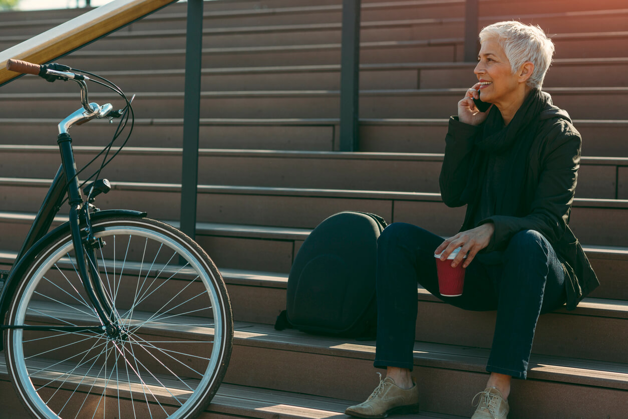 Woman sitting on steps with her bike on the way to work