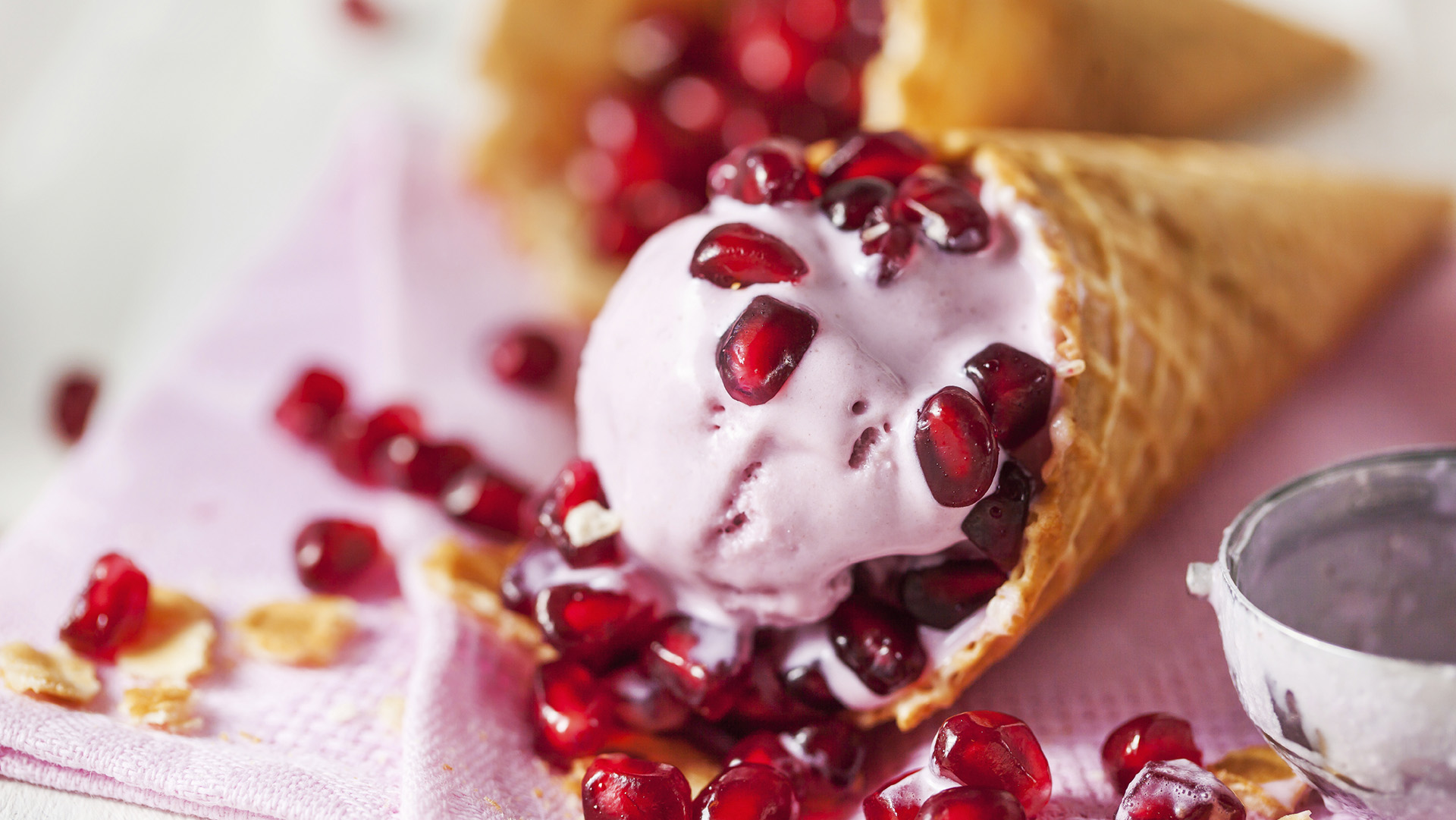 Ice cream in a waffle cone with pomegranate seeds