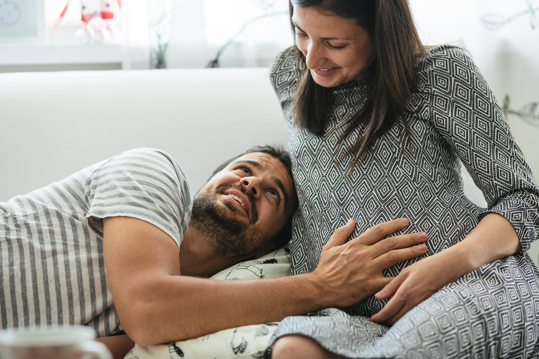 Happy couple enjoyng the comfort of their home, expecting a baby