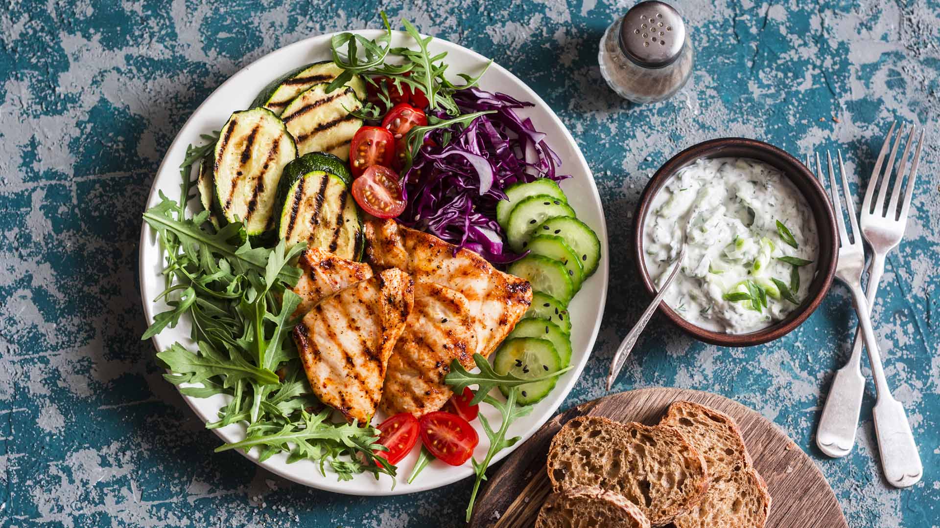 Grilled chicken breast, zucchini and garden vegetable power bowl. Healthy diet food concept, top view