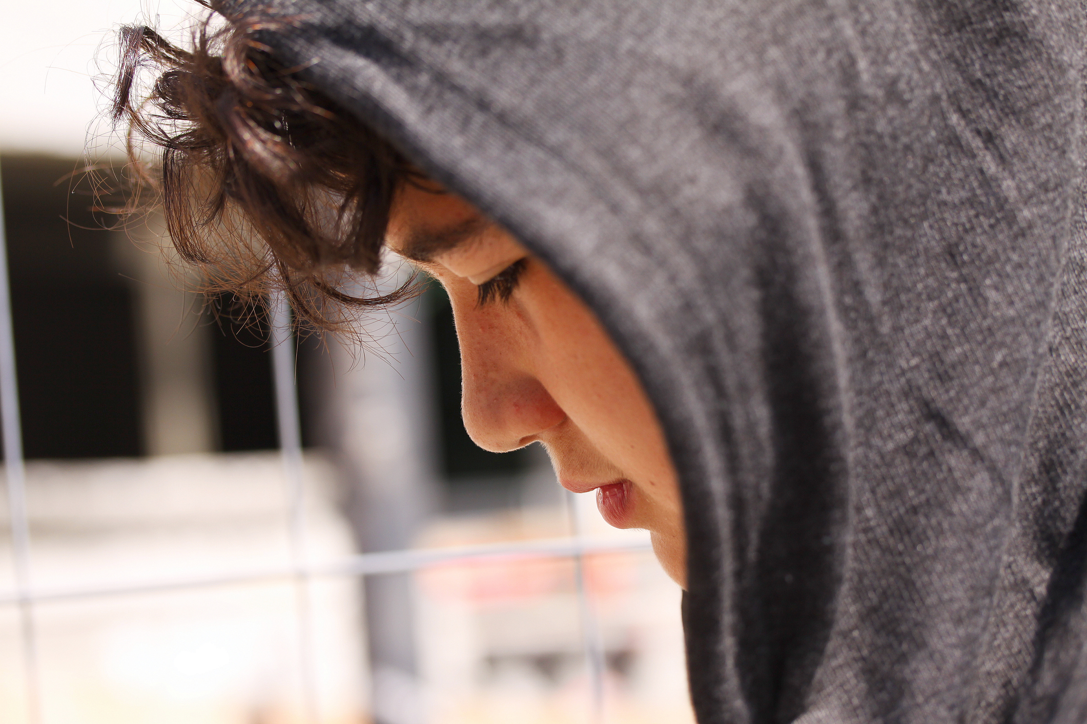 Sad troubled hispanic school boy teenager wearing a hoodie posing outdoor - close up stock photo