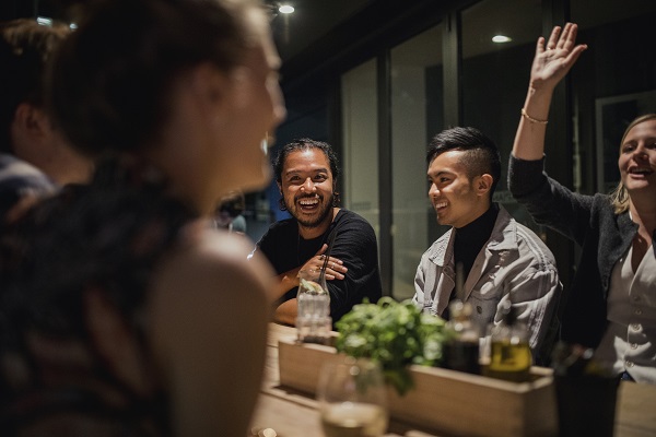 A medium sized group of friends enjoying a couple of drinks after work.