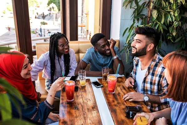 Group of happy friends drinking juice and lemonade at cafe. Friendship, youth and food concept.