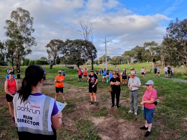 A parkrun volunteer speaks to a crowd