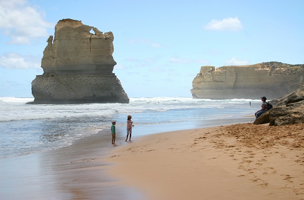 Two children play on the beach close to the 12 Apostles