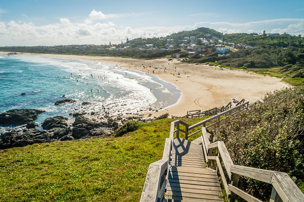 A set of stairs leading down to the beach on a sunny day