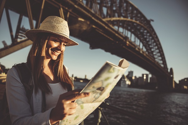 Woman traveler holding city map in the sunset