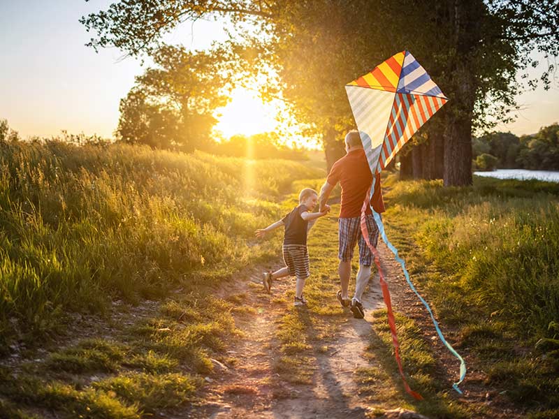 Grandfather and son flying kite