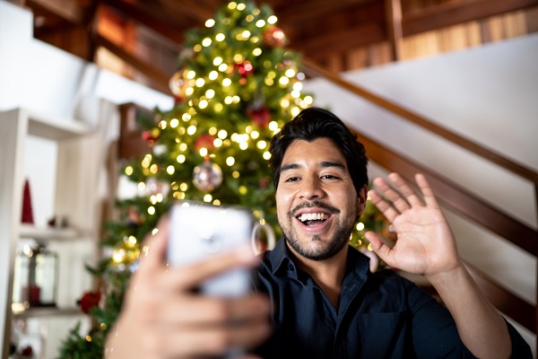 Man doing a video call on smartphone showing christmas tree