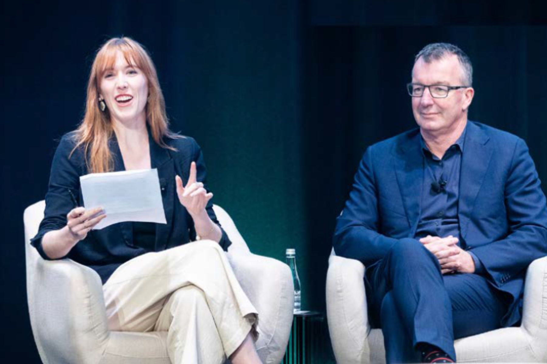 A man and woman sitting on a stage