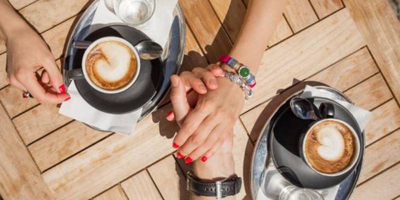 holding hands over a coffee
