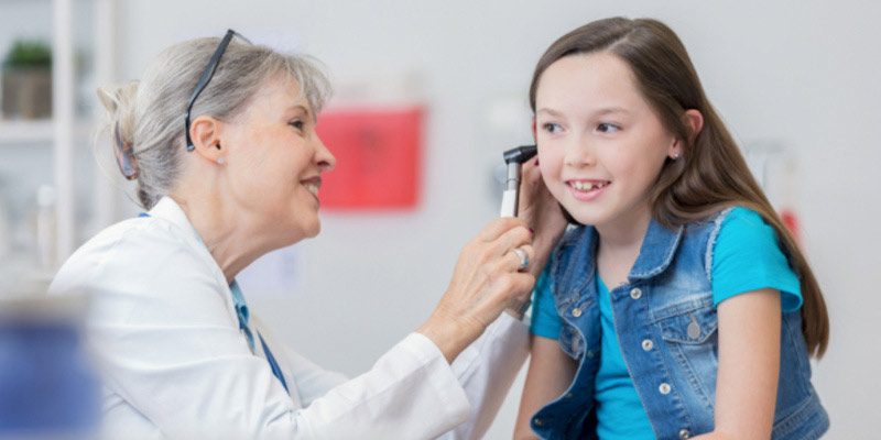 A child getting their ears assessed