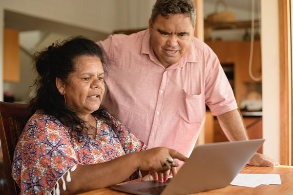 Couple having a discussion while looking at a laptop