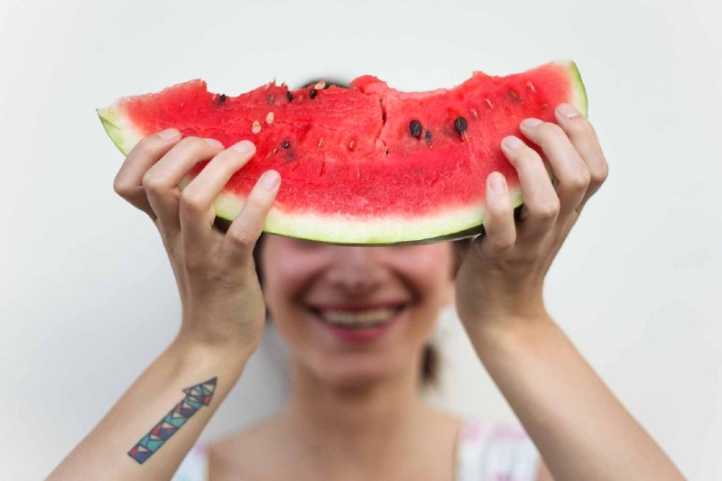 woman holding up a watermelon