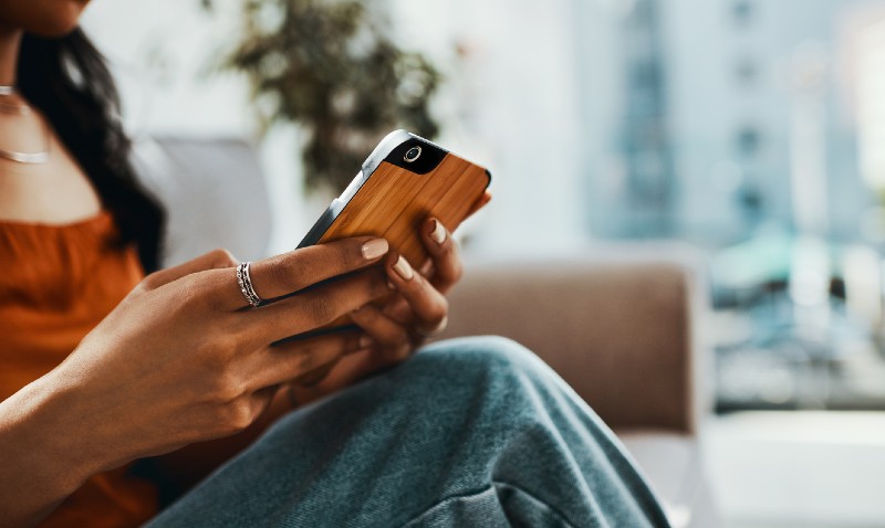 A person sitting down, looking at their phone