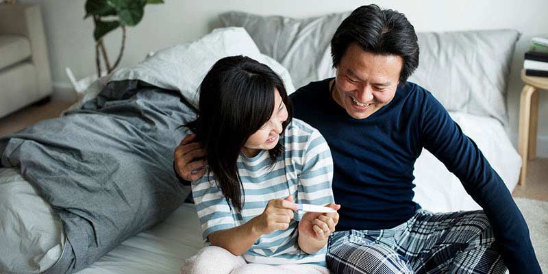 A couple holding a positive pregnancy test