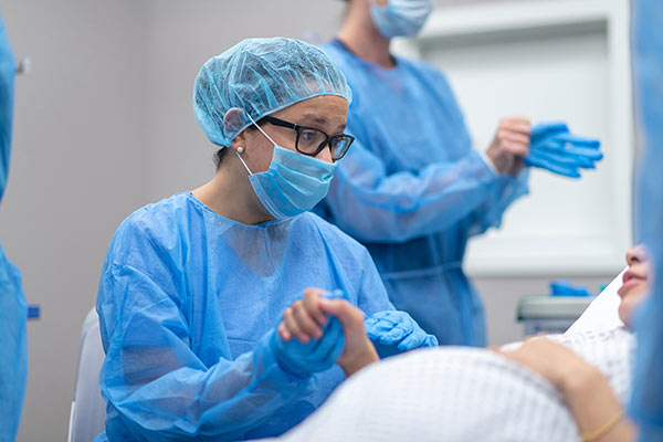 Health professional holding hand of pregnant woman in hospital