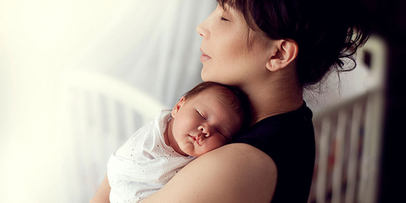 A mum cuddling her newborn baby