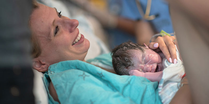A new mother embracing her newborn