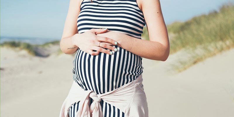 Pregnant female standing on beach