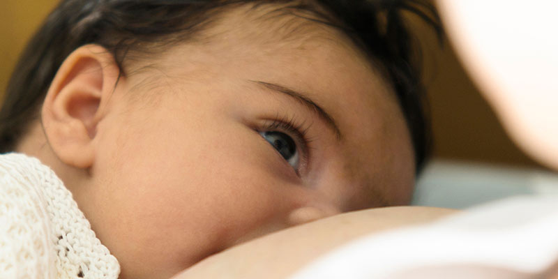 A close-up of a baby being breast-fed