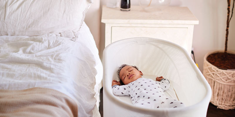 A sleeping baby in a bassinet
