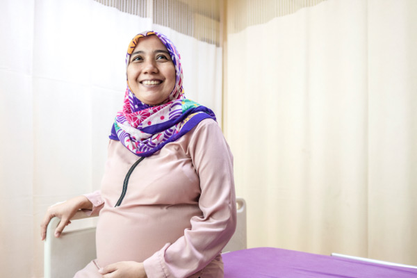 Pregnant woman sitting on hospital bed