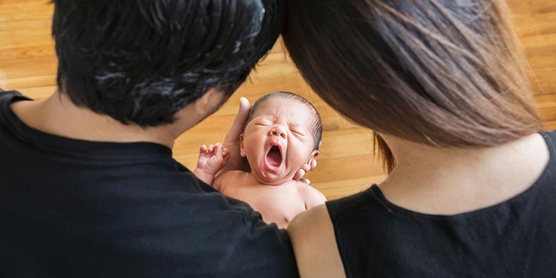 A couple embracing their newborn