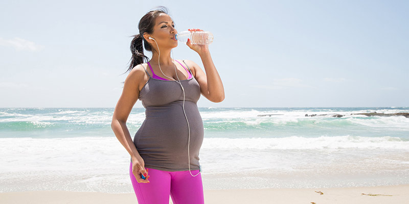 A woman drinking water after exercising