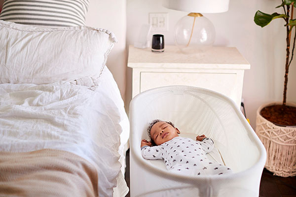 A sleeping newborn in its bassinet