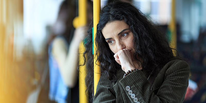 woman looking anxious on public transport