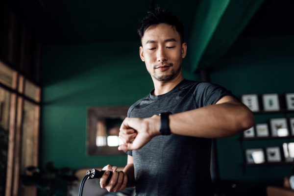 person checking watch with skipping rope