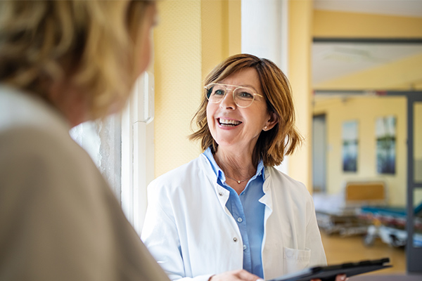 doctor holding a clipboard smiling at a patient