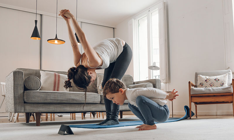 woman exercising at home with her young son